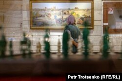 Посетительница рассматривает картину на выставке конфискованного антиквариата