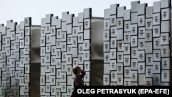 Жінка біля меморіалу жертвам воєнних злочинів у Бучі, Київська область, 17 вересня 2023 року