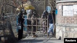 2022-nji ýylyň dekabry. Kabul uniwersitetiniň derwezesiniň alnynda duran talyp gyz. Geçen ýylyň güýzünde "Talyban" gyzlara ýokary okuw jaýlarynda okamagy gadagan etdi.