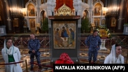 A Russian Orthodox believer bows before Andrei Rublev's Trinity icon on exhibit at the Christ the Savior Cathedral in Moscow in June.