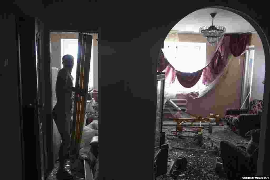 A man begins the task of cleaning up his apartment. Moscow has denied deliberately targeting civilians, but its missile and drone attacks have repeatedly struck residential areas in cities across Ukraine.