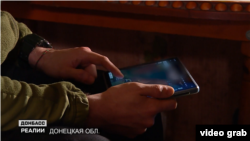 Ротний спостерігає за роботою танка на передовій через планшет