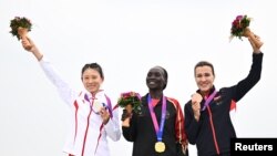 Марафондук жарыштын жеңүүчүлөрдү сыйлоо аземи.  Юнис Чебичи Чумба (ортодо), Чжан Дэшунь (солдо) жана Сардана Трофимова (оңдо). Ханчжоу шаары. 5-октябрь, 2023-жыл. 