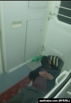 Otly wagonlarynyň arasyndaky geçelgede ýatan bir ýolagçy. 2023 ý.