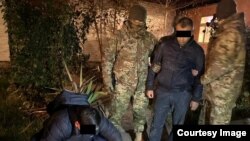 Шектүү М.Т.А. акча менен кармалгандагы фото. Сүрөт УКМКга таандык.