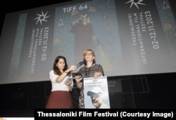 ندا میهن‌دوست در حال خواندن پیام برادرش در جشنواره تسالونیکی