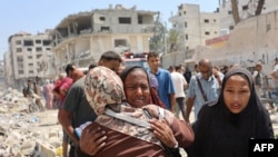 Качкындар жайгашкан мектептин имаратына урулган израил аба соккусунан жабыркаган палестиндер.  20-август, 2024-жыл. Газа тилкеси.
