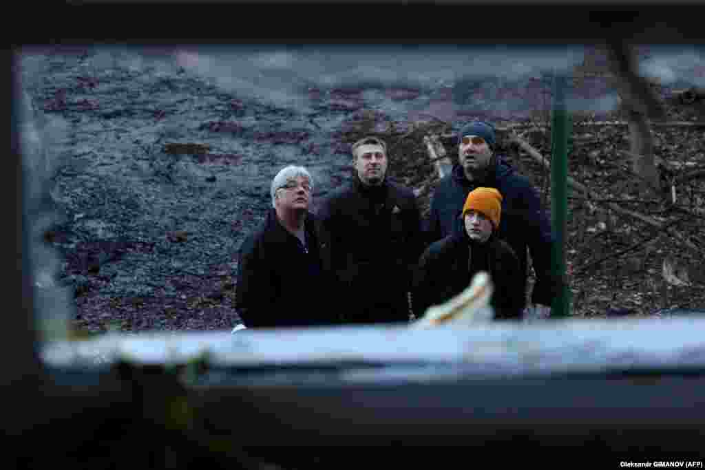 Residents view the damage to a residential area in Odesa. The falling drone debris hit residential buildings, damaging a gas pipe and a dozen cars in one of the port&#39;s districts, the Interior Ministry said.&nbsp;