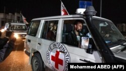 ХАМАС радикал уюмунун барымтасынан бошотулгандарды Кызыл Чырым уюмунун өкүлдөрү алып баратышат. 26-ноябрь, 2023-жыл. 