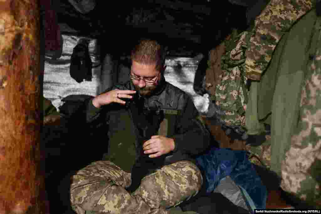 Дощ знову посилюється, йдемо до сусідніх позицій, ховаємось в бліндажі, де військові бавляться з кошеням