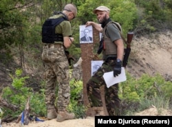 Бійці стрілецького батальйону «Карпатська Січ» готують мішені із зображенням президента Росії Володимира Путіна під час навчань для новобранців на стрільбищі в Харківській області, 30 червня 2022 року