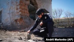Поліцейський оглядає уламки керованої бомби після удару військ РФ по Харкову, 30 квітня 2024 року