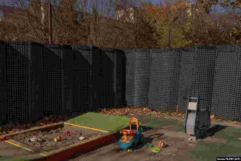 Захисний паркан від обстрілів оточує дитячий майданчик у Херсоні. Херсон розташований на контрольованому владою України західному березі Дніпра, який де-факто є лінією фронту. У міру загострення бойових дій з обох сторін батьки стикаються з важким рішенням: чи всією сім&rsquo;єю сміливо витримати невпинні російські обстріли, чи відвезти своїх дітей у безпечне місце