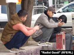 Смартфонға үңіліп отырған адамдар (көрнекі сурет)