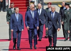 بایدن هنگام ورود به تل‌آویو در میان رهبران اسرائیل؛ بنت کمی دورتر روی فرش قرمز راه می‌رود