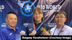 Нурзат Нуртаева жеке машыктыруучусу Үсөн Рыскулов жана кыз-келиндер күрөшү боюнча жаштар курама командасынын улук машыктыруучусу, Кыргызстандын күрөш федерациясынын вице-президенти Байгазы Кенжебаев менен. 18-август, 2022-ж. София, Болгария. 