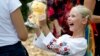 A Ukrainian refugee girl receives a Teddy bear during an event for refugee children in Bucharest, Romania, on August 24.