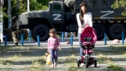 Жители оккупированной Россией части Херсонской области на фоне российской военной техники