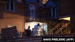 Emergency service personnel, police, and investigators work at the scene of the shooting in Cetinje on August 12.