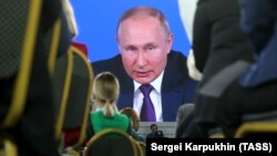 Президент РФ Владимир Путин (на экране) во время ежегодной большой пресс-конференции в Центральном выставочном зале «Манеж». Россия. Москва, 23 декабря 2021 года