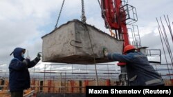 RUSSIA - Workers work atop of one of the skyscrapers of Capital Towers residential complex under construction in Moscow, May 18, 2020. 