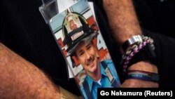 11-сентябрдагы теракттын курмандыгы, өрт өчүрүүчү, лейтенант Дэниел О'Каллагандын сүрөтүн анын агасы кармап турду. Нью-Йорк. 11-сентябрь, 2021-жыл.