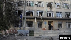 A man stands at the entrance to a building in Odesa that was damaged by a drone strike on February 8. 