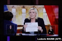 صحنه‌ای از مناظره دو نامزد که لوپن در آن سعی دارد با نشان دادن توئیتی از سال ۲۰۱۴، عدم ارتباطش را با روسیه اثبات کند.