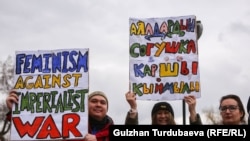 Согушту айыптаган плакатты кармаган катышуучулар.