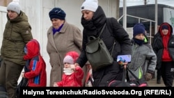 Українські жінки з дітьми переходять через пункт пропуску Шегині із України у Польщу. 8 березня 2022 року