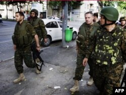 Министр обороны Давид Кезерашвили (первый слева) в Гори после российской бомбежки. 12 августа 2008 г.