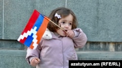Nagorno-Karabakh - A girl holds a Karabakh flag in Stepanakert, December 25, 2022.