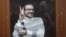 Ilya Yashin gestures inside a defendant's cage prior to his court hearing in Moscow on December 9. 