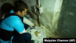 Лікар показує тіла дітей, загиблих під час обстрілу лікарні №3 в Маріуполі, 15 березня 2022 року. Фото Мстислава Чернова