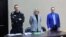 Aleksei Navalny (left) appears with his lawyers Olga Mikhailova (center) and Vadim Kobzev appear via a video link during a court hearing in March 2022.