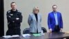 Russian opposition leader Aleksei Navalny (left) is seen with his lawyers Olga Mikhailova and Vadim Kobzev during a court hearing in March 2022.