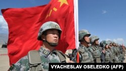 Кытай жоокери Шанхай кызматташтык уюмунун (ШККУ) Бишкектен 200 км.дей аралыкта жайгашкан Балыкчыдагы “Эдельвейс” полигонунда “Тынчтык миссия – 2016” биргелешкен аскердик машыгуусун өткөрүү убагында туу көтөрүп турат. 2016-жыл, 19-сентябрь