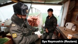 Российский полицейский проверяет документы иностранного гражданина. Иллюстративное фото.