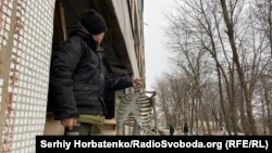 У розбитій школі: учень тримає залишки наочності у кабінеті біології