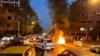 A police motorcycle burns as protesters take to the streets in Tehran. 