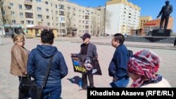 Юрист Ербол Аккужанов на площади имени Ауэзова в городе Семей держит плакат надписью: «No war» («Нет войне»).  Семей, 15 апреля 2022 года 