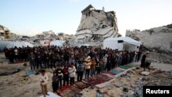 فلسطینیان غزه در حال برگزاری نماز عید فطر در جبالیا، همزمان با ادامۀ حملات اسرائیل به نوار غزه