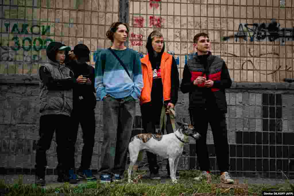 Підлітки дивляться на наслідки російських обстрілів їхнього міста.&nbsp; Щонайменше 16 українських міст зазнали ракетних та дронових атак. Багато з цих міст не обстрілювалися Росією з весни цього року