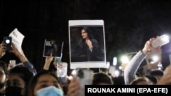 Махса Амининин сүрөтүн кармаган демонстранттар. Иран.