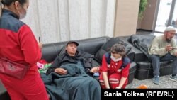 Работники медицинской бригады проводят осмотр одного из рабочих компании «КЕЗБИ»  в холле здания КМГ. Нур-Султан, 16 мая 2022 года 