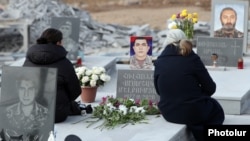 Armenia - Women visit one of the graves of Armenian soldiers killed in the 2020 war in Nagorno-Karabakh and buried in the Yerablur Military Pantheon in Yerevan, January 28, 2022.