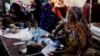 Women affected by the floods sit with their children suffering from malaria as they receive medical assistance at the Sayed Abdullah Shah Institute of Medical Sciences in Sehwan, Pakistan, on September 29.