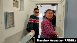 Адвокат Галым Нурпеисов (в красном) и журналист Думан Мухаммедкарим в управлении полиции. 12 октября 2022 года 