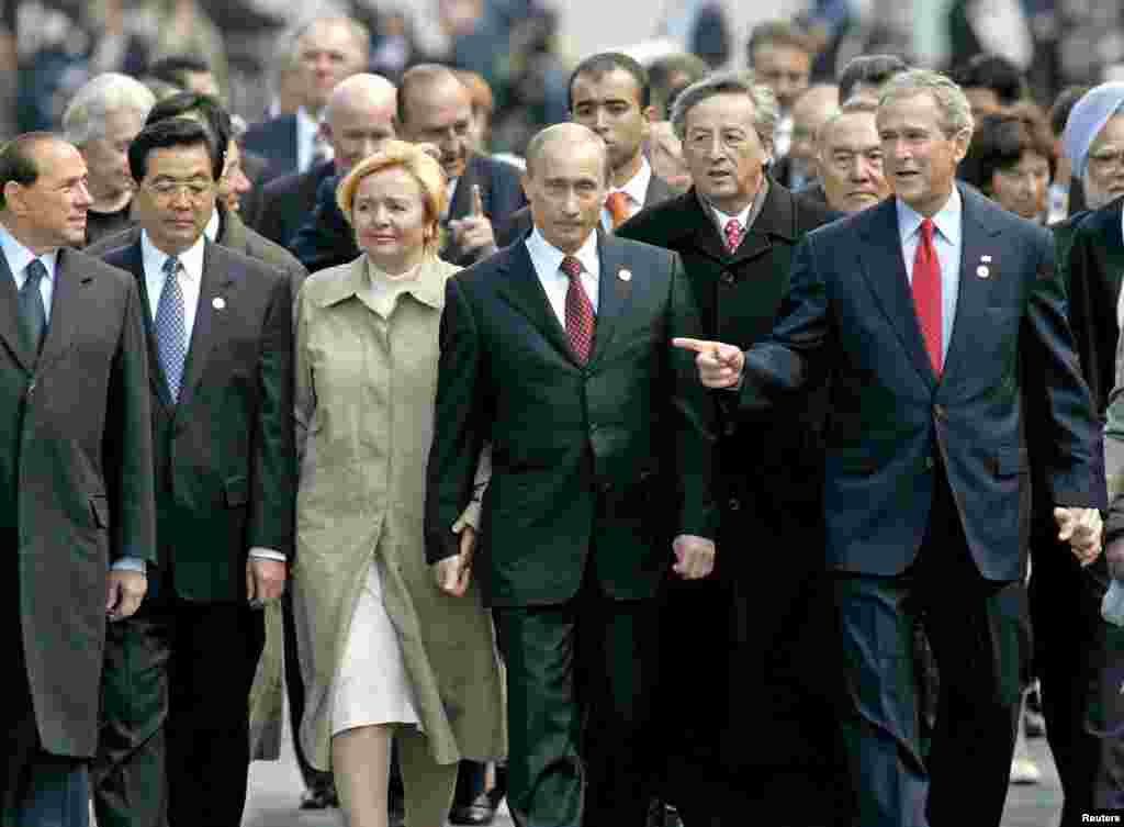 نخست‌وزیر ایتالیا سیلویو برلوسکونی، رئیس‌جمهور چین هو جینتائو، رئیس‌جمهور پوتین و همسرش لیودمیلا، رئیس اتحادیه اروپا ژان‌کلود یونکر و رئیس‌جمهور آمریکا جورج دبلیو بوش، پس از شرکت در مراسم بزرگداشت جنگ جهانی دوم در میدان سرخ، کرملین، مسکو، ۹ مه ۲۰۰۵ 