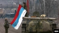 Соьлжа-ГIалара Оьрсийчоьнан эскархой, 2000-чу шеран чиллан-бутт. ТIеман машенна тIе йаздина ду: "И харц белахь а - сан даймохк бу!". Гайтаман сурт